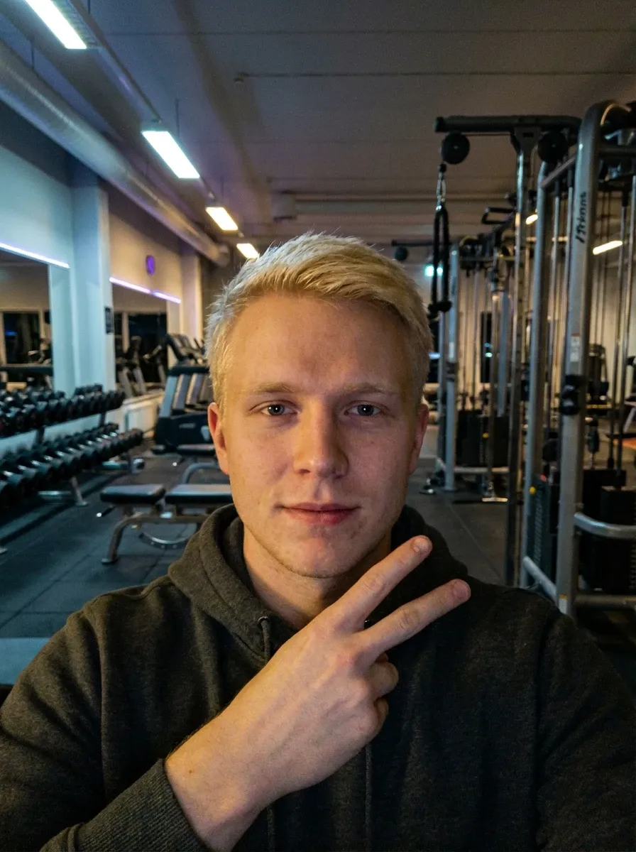 Original selfie input — blond man in a dark hoodie at the gym